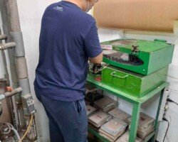 作業員配戴專業防護耳罩,在防護檢測箱前進行零件的氣爆測試,以確保產品在高壓環境下的安全性。