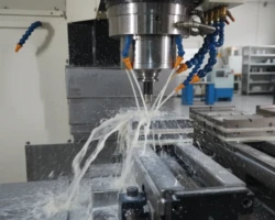 CNC 銑床正在進行金屬加工,切削液噴灑在旋轉的刀具與工件上以進行冷卻與潤滑。