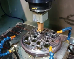 放電加工機(EDM)正在對金屬模具進行精密加工,上方裝有 System 3R 夾具與電極,準備進入工件孔位。